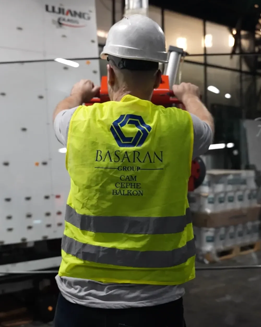 Başaran üretim tesisinde cam panel taşıyan çalışan